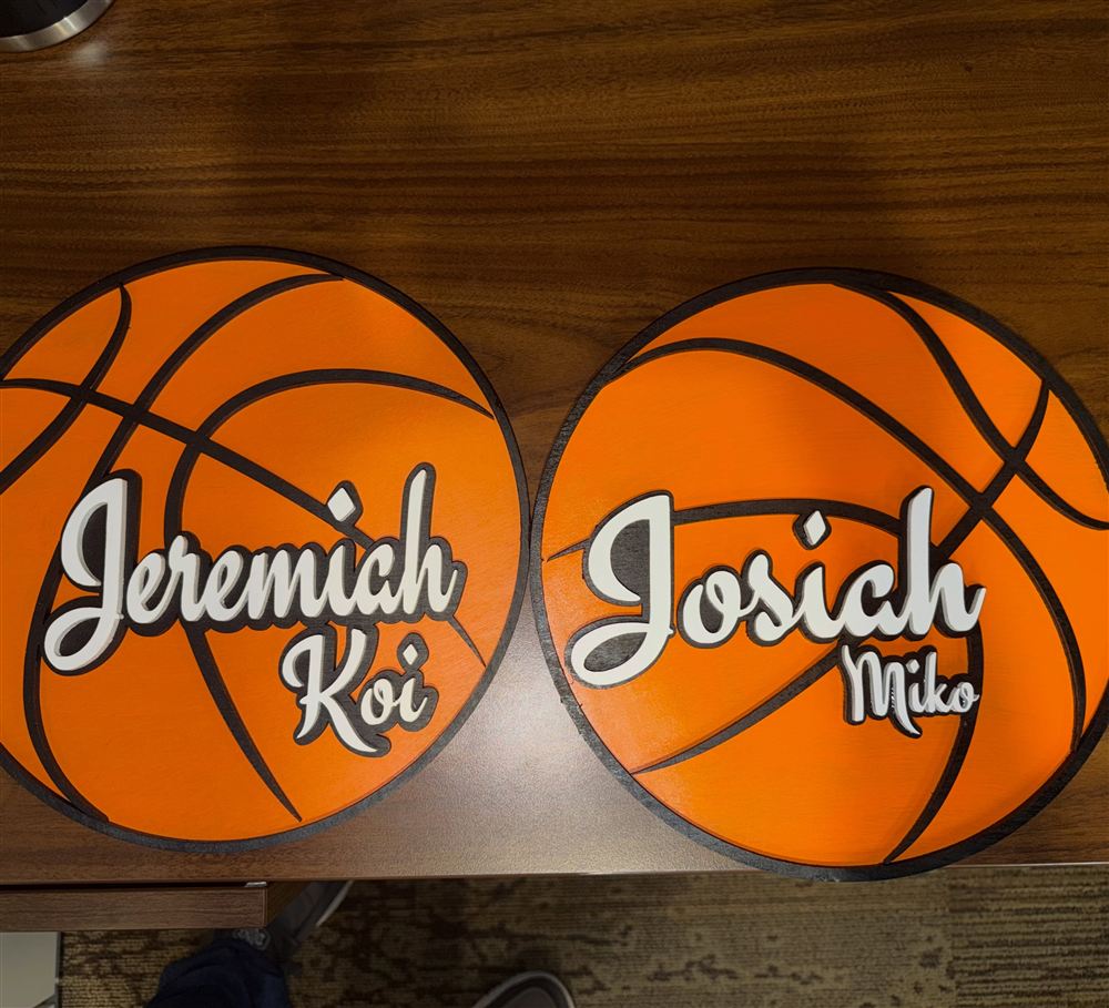 Two painted basketball name signs with raised cream lettering