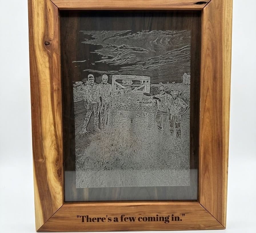 A family photo laser engraved on dark stock inside a cedar frame with an engraved caption