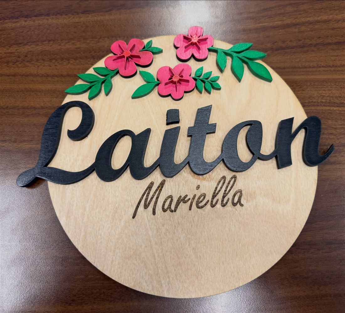 Birch name round with the name Laiton cut in black script, Mariella engraved below, and painted pink flowers